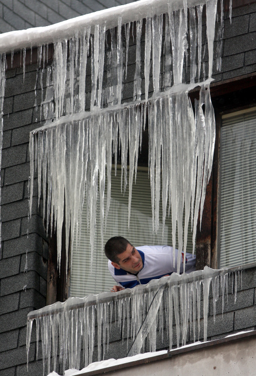 A man views icicles on a window in Uzice, 200 kilometers southwest of Belgrade, Serbia, Thursday. (AP-Yonhap News)