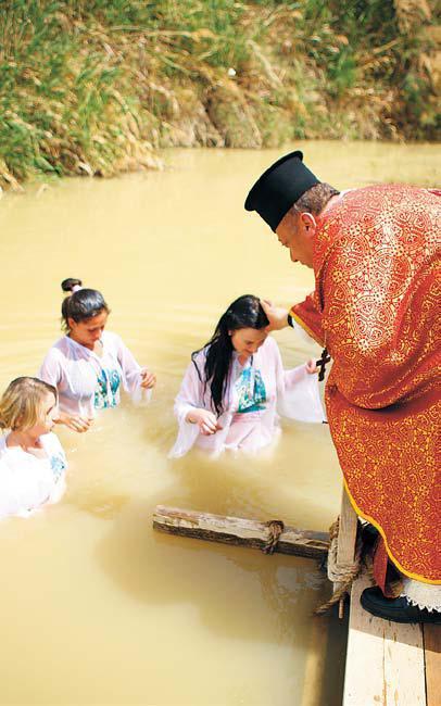 Christians baptized by a priest in the River Jordan (Jordanian Tourism & Antiquities Ministry)