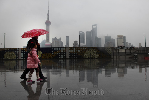 Pedestrians walk near the Lujiazui Financial District in the distance in Shanghai. (Bloomberg)