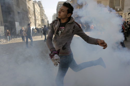 An Egyptian protester is caught in tear gas during clashes with security forces near the Egyptian Interior Ministry in Cairo, Egypt, Sunday, Feb. 5, 2012. (AP)