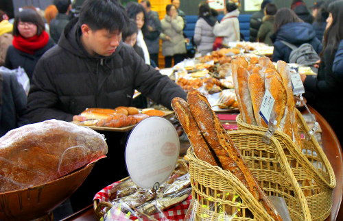 Customers shop for bread at a local bakery