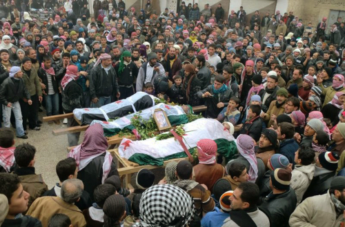 Mourners gather around the bodies of people allegedly killed by government forces, during a funeral procession in Maarat al-Noman, Idlib province, Syria on Wednesday. (AP-Yonhap News)