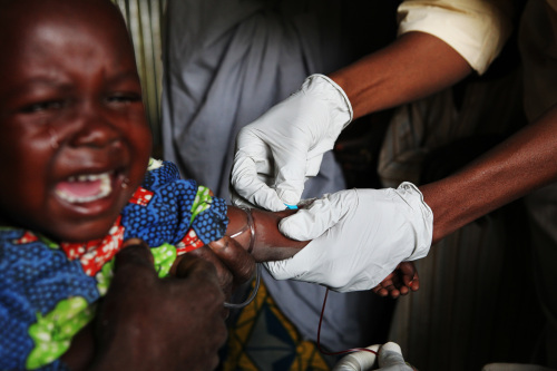 A doctor from Medecins sans Frontiers (MSF), right, takes a blood sample to determine a young girl's lead level at a clinic in the village of Abare, northern Nigeria, on Tuesday, Dec. 7, 2010. At least 284 children under the age of five have died from lead poisoning in eight villages in Nigeria's Zamfara state as a result of small-scale gold mining, according to government officials. (Bloomberg)