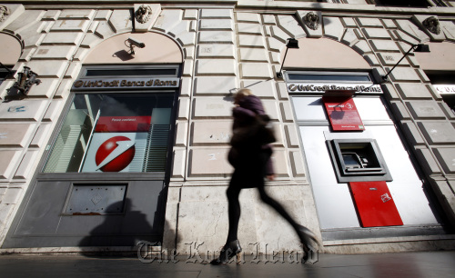 A pedestrian passes a branch of the UniCredit SpA bank in Rome. (Bloomberg)