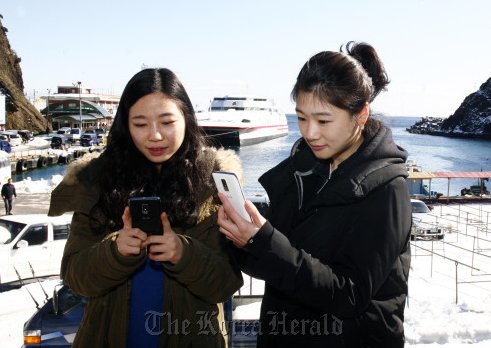 Ryou Hye-rim (right) and Kim Jung-eun take part in an LG Uplus event that took people to Ulleungdo for three days to test the company’s 4G network from Friday to Sunday. (LG Uplus)