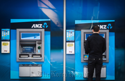 A customer uses an automated teller machine outside an Australia & New Zealand Banking Group Ltd. branch in Sydney. (Bloomberg)