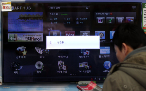 A customer checks out a smart TV at a store in Seoul on Friday. (Yonhap News)