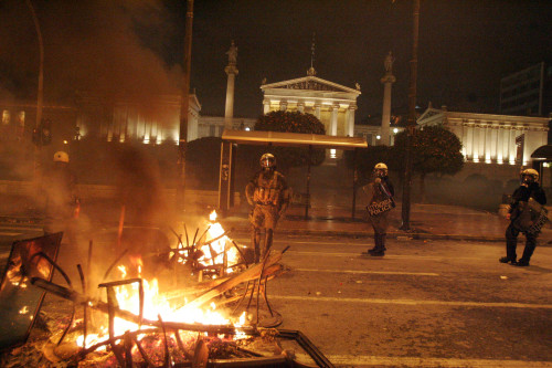 Fire is seen during clashes between protesters and riot police in central Athens on Sunday. (Xinhua)