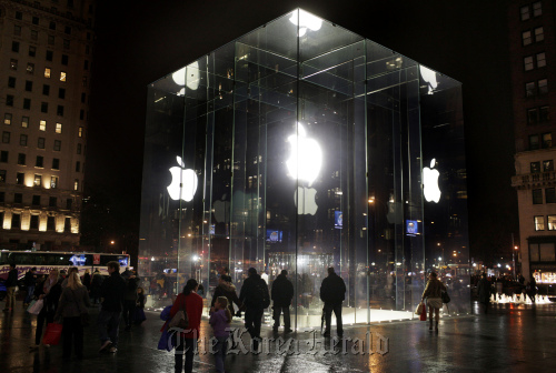 Shoppers walk near the entrance to the Apple Inc. store on Fifth Avenue in Manhattan, New York. (Bloomberg)