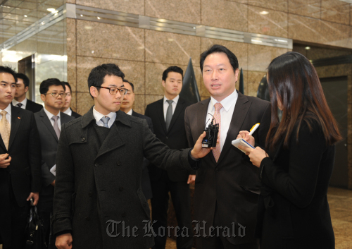 SK Group chairman Chey Tae-won (second from right) takes questions from reporters as he enters the Hynix building in southern Seoul to attend a board meeting where he was appointed co-CEO of the chipmaker on Tuesday. (Hynix)