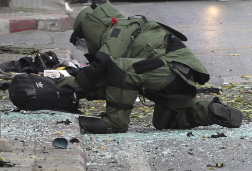 A Thai Explosive Ordnance Disposal official checks a backpack that was left at the bomb site by a suspect bomber in Bangkok on Tuesday. (AP-Yonhap News)