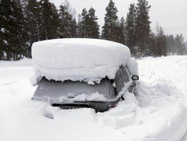 A snowed covered car sits roadside in the woods north of Umea in Northern Sweden on Saturday. (AFP)