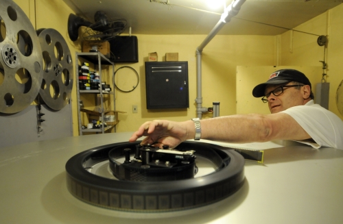 Arnie Herdendorf feeds film into the platters in the projection room at the Palace Theater, in Lockport, New York on Sunday. (AP-Yonhap News)