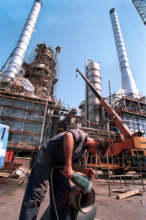 In this Sept. 27, 2000 file photo, an Iranian oil worker repairs a pipe at an oil refinery in Tehran. Iran has halted oil shipments to Britain and France, the Oil Ministry said Sunday, in an apparent pre-emptive blow against the European Union after the bloc imposed sanctions on Iran`s crucial fuel exports. (AP-Yonhap News)