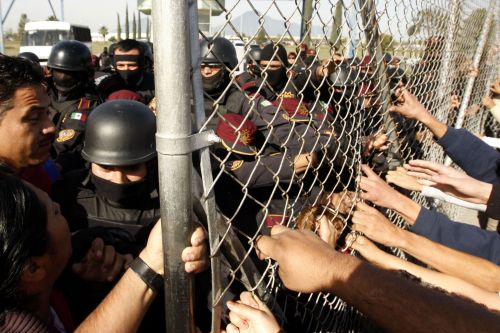 Relatives of inmates at Apodaca prison, pull the security fence following a riot inside the prison, Sunday, near Monterrey, state of Nuevo Leon, Mexico. (AFP-Yonhap News)