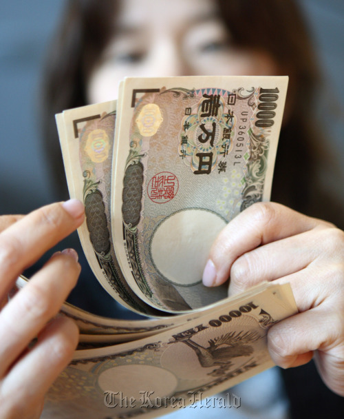 A woman arranges Japanese 10,000 yen notes for a photograph in Tokyo. (Bloomberg)