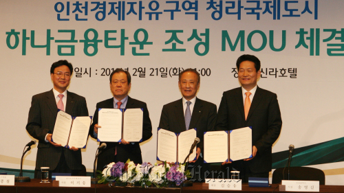 Hana Financial Group chairman Kim Seung-yu (second from right) and Incheon Mayor Song Young-gil (right) pose after signing a pact to set up the “Hana Financial Town” at the Cheongna district of the Incheon Free Economic Zone at a hotel in Seoul on Tuesday. (Hana Financial)