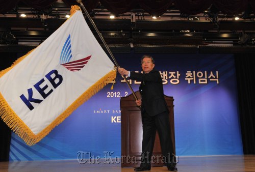 New KEB CEO Yun Yong-ro waves the bank’s flag at his inauguration Wednesday. (Lee Sang-sub/The Korea Herald)