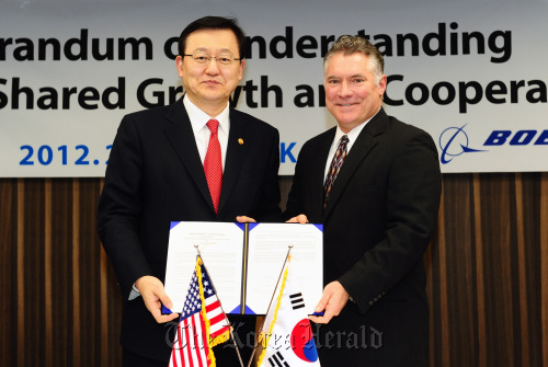 Knowledge Economy Minister Hong Suk-woo (left) and Boeing Korea president Pat Gaines pose after signing an agreement for collaboration between Korean firms and the U.S. aerospace company on developing parts and materials for aircraft at a ceremony in Seoul on Wednesday. (MKE)
