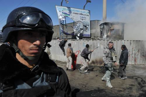 Afghan men extinguish a fire at an enclosed base belonging to foreigners during a protest against Koran desecration in Kabul on February 22, 2012. Furious Afghans threw rocks and screamed 