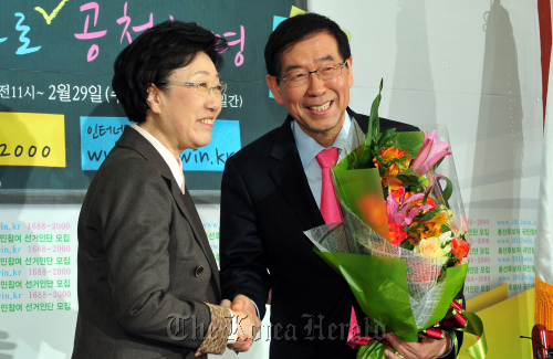 Seoul Mayor Park Won-soon (right) shakes hands with Democratic United Party chairperson Han Myeong-sook in a ceremony marking his entry into the party in Seoul on Thursday. (Park Hyun-koo/The Korea Herald)