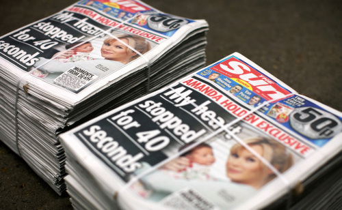 Stacks of the first Sunday edition of the Sun newspaper, The Sun on Sunday, are displayed at a supermarket in Slough, U.K. on Sunday, Feb. 26, 2012. (Bloomberg)