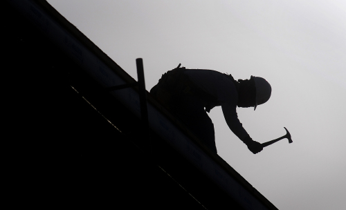 A contractor works on a roof at the Civita housing development construction site in San Diego, California, U.S., on Tuesday, Feb. 28, 2012. (Bloomberg)