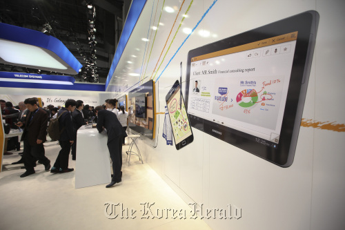 An illuminated image of a Samsung Electronics Co. tablet and Galaxy smartphones are seen on display at the company`s booth at the Mobile World Congress in Barcelona, Spain, Tuesday. (Bloomberg)