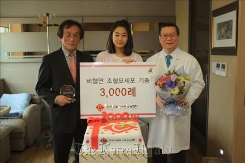 The nation’s 3,000th bone marrow donor Kim Ji-in (center) poses for a photo with Hwang Tai-ju (left), president of Korea Marrow Donor Program, and Lee Hong-ki, a hematology doctor at Konkuk University Medical Center. (Yonhap News)