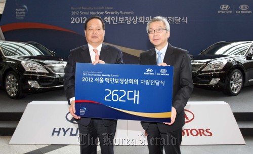 Hyundai Motor president Kim Choong-ho (left) poses after delivering protocol vehicles to the preparation committee for the 2012 Nuclear Security Summit at the COEX in southern Seoul on Monday. (Hyundai Motor)