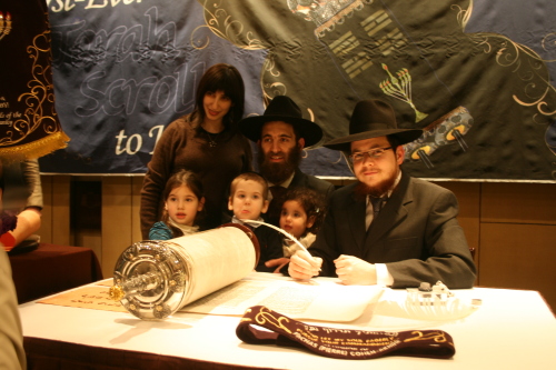 Rabbi Osher Litzman (center) and family pose with a scribe (right) after completing the second-to-last letter of the Torah on Sunday.(Paul Kerry/The Korea Herald)