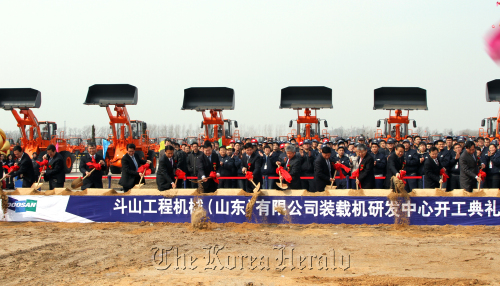 Doosan Infracore’s chief of Chinese operations Nam Don-keun (front, eighth from left) and other officials break ground for the Korean engineering company’s research and development center Yantai, eastern China, Tuesday. (Doosan Infracore Co.)