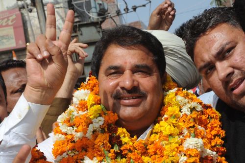 The Congress party candidate for the Member of Legislative Assembly (MLA) Om Parkash Sonia (C) along with supporters flashes the victory sign after the announcement of results in his favour outside a counting center in Amritsar on March 6, 2012. (AFP)