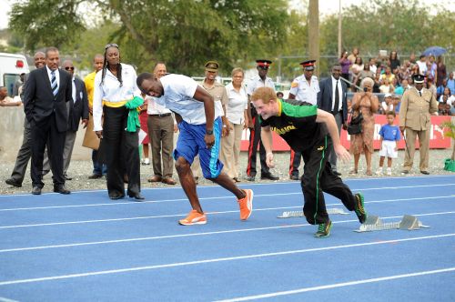 Britain’s Prince Harry and Usain Bolt, Jamaica’s champion sprinter, come out of the starting blocks on the track at the University of the West Indies in Kingston, Jamaica, Tuesday. (AFP-Yonhap News)