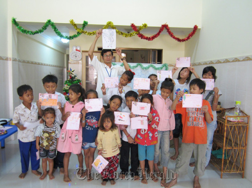 Cambodian children show drawings during a class at the Ewha Social Welfare Center. (Ewha Womans University)