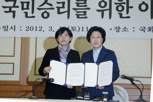 Democratic United Party chairwoman Han Myeong-sook (right) poses with Lee Jung-hee, the chief of the minor opposition wing Unified Progressive Party, after they agreed on an election alliance at the National Assembly in Yeouido, Seoul, Saturday. (Yonhap News)