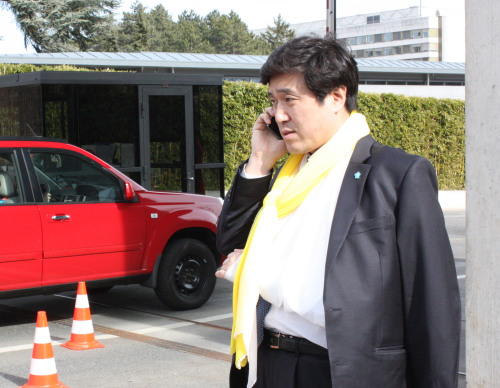 Rep. Ahn Hyung-hwan of the Saenuri Party talks on the phone after receiving medical treatment in Geneva, Monday. He had a scuffle while trying to approach So Se-pyong, North Korean ambassador to Geneva, to urge him not to ask China to repatriate North Korean defectors. (Yonhap News)