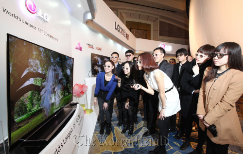 People experience LG’s 55-inch 3-D OLED TV in Beijing on Tuesday. (LG Electronics)