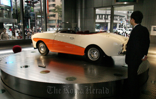 Customers look at an old Nissan “Datsun Sport S211” car at in a Nissan Motor Co. showroom in Tokyo. (Bloomberg)