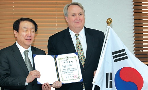 John Linton (right), director of Severance Hospital International Health Care Center, poses for a photo with the Justice Minister Kwon Jae-jin, holding his Korean citizenship, in the ministry building in Gwacheon, Gyeonggi Province, Wednesday. (Yonhap News)