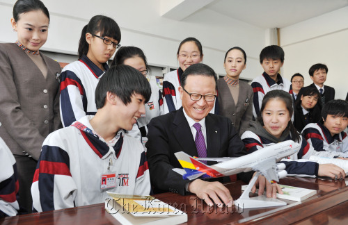 Asiana Airlines chief executive Yoon Young-doo (center) speaks about how an airplane operates to students at a middle school in Tumen, China, on Thursday after donating books to the school. (Asiana Airlines)