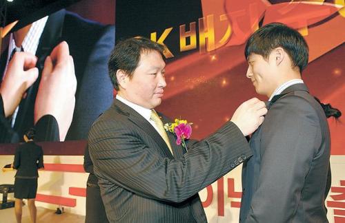 SK Group chairman Chey Tae-won (left) attaches an SK badge to a new Hynix employee during an inauguration event at the company’s headquarters in Icheon, Gyeonggi Province, on Monday. (SK Hynix)