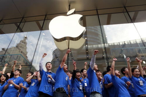 Apple Inc. employees cheer at the official opening of the company’s new store in Shanghai. (Bloomberg)