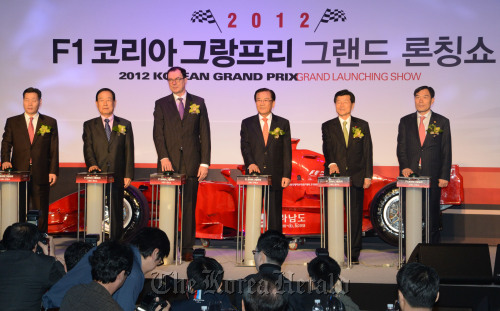 South Jeolla Province Gov. Park Joon-yung (third from right) and Korea Tourism Organization president Lee Charm (third from left) pose for photo at a launching ceremony of Korea’s F1 ticket distribution at the InterContinental Hotel in Seoul on Wednesday. (Chung Hee-cho/The Korea Herald)