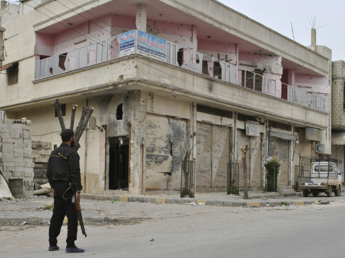 Syrian rebel stands guard in front of a damaged building, at Khaldiyeh neighborhoods in Homs province, central Syria. (AP-Yonhap News)