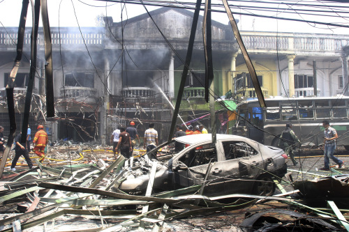 Thai firefighters and soldiers walk at the site of the car bomb attack in Yala province, southern Thailand on Saturday. ( AP-Yonhap News)