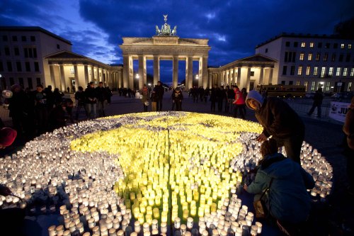 Volunteers of the World Wide Fund For Nature place about 5000 candles to picture the globe prior to “Earth Hour” in front of the Brandenburg Gate in Berlin on Saturday. (AP-Yonhap News)