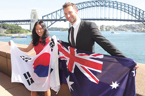 Korean-born fashion designer Bae Yeo-jin and swimmer Ian Thorpe hold up Australian and Korean flags in Sydney to celebrate becoming Australia’s Yeosu Expo ambassadors.