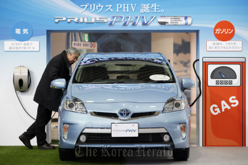 A visitor looks at a Toyota Motor Corp. Prius plug-in hybrid vehicle displayed at the company’s showroom in Tokyo. (Bloomberg)