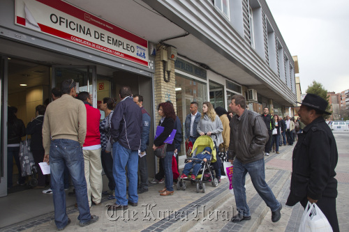 Job-seekers wait outside a job center before opening in Madrid on Monday. (Bloomberg)